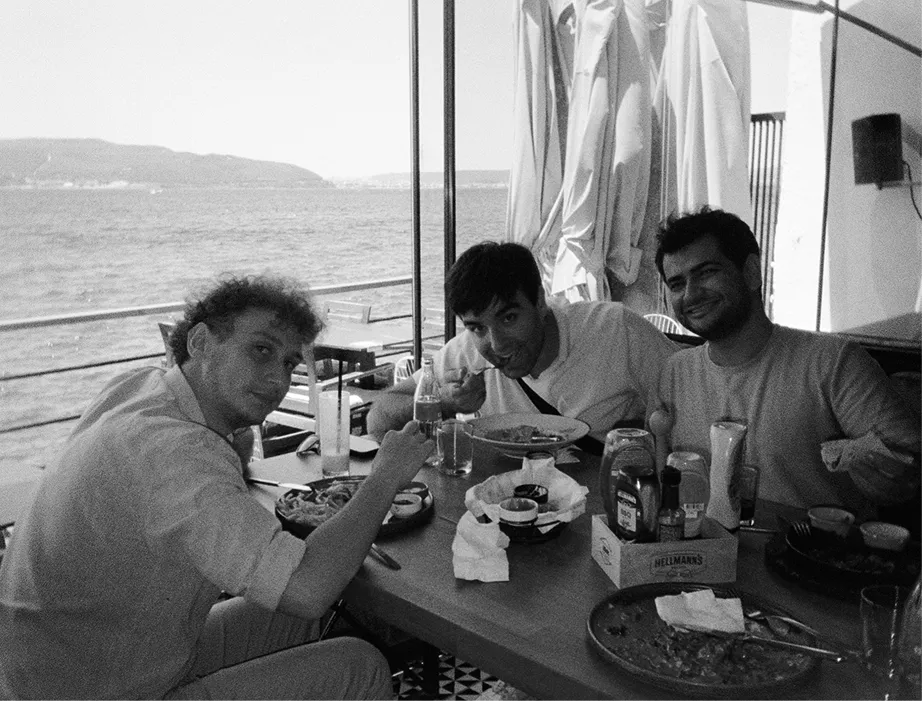 Three node101 team members at lunch by the sea